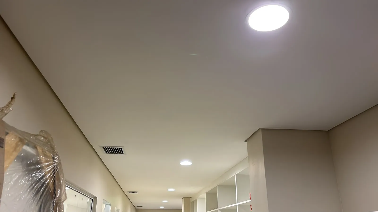 Corredor com forro liso de drywall e spots de iluminação